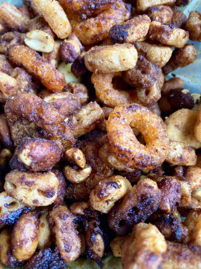 Homemade Nuts and Bolts snack mix cooling on a baking tray